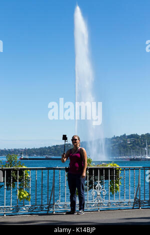 Turistico / turisti prendere una fotografia selfie nella parte anteriore del Jet d'Eau alta fontana sul lago svizzero, sul Lago di Ginevra / Lac Leman a Ginevra / Geneve, Svizzera Foto Stock