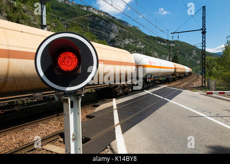 Treno veloce e un segnale di traffico rosso mostra / lampeggiante / luci di avvertimento per le auto a una ferrovia francese ferrovia ferrovia automatica passaggio a livello in Francia. Foto Stock