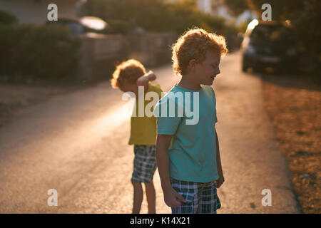 Due curiose piccoli fratellini su strada Foto Stock