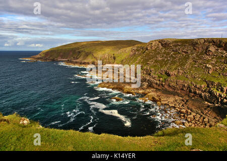 Rocky seashore sullo Scottish west coast con ripide scogliere, onde, cielo, nuvole Foto Stock