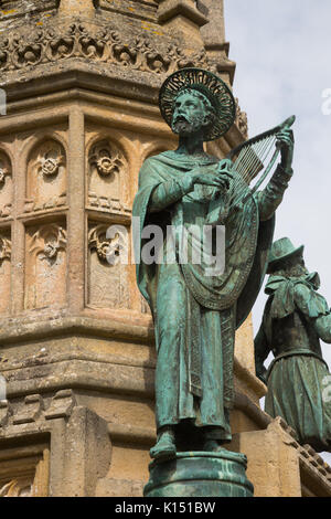 Statua religiosa di San Aldhelm suona l'arpa sul Digby Memorial al di fuori della chiesa abbaziale di Santa Maria Vergine (Sherborne Abbey), Sherborne, Dorset Foto Stock