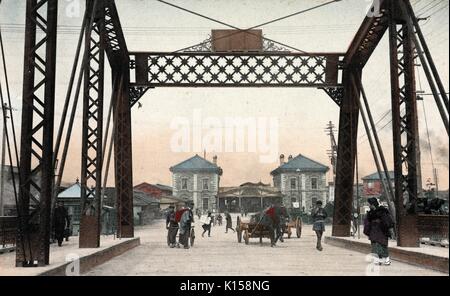 Mano cartolina colorata alla Stazione di Yokohama, mostrare alla gente e di un carrello che va oltre un ponte, Giappone, 1912. Dalla Biblioteca Pubblica di New York. Foto Stock