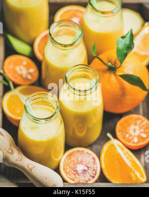 Un sano frullato giallo in bottiglie con frutta fresca Foto Stock