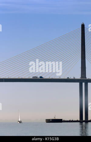 Una barca a vela passa sotto il Bob Graham Sunshine Skyway Bridge, Baia di Tampa, Florida Foto Stock