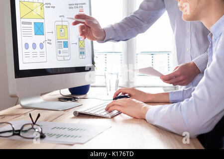 Sito web del team di sviluppo delineando wireframe design layout per reattivo contenuto web, due UI/UX front end designer in ufficio Foto Stock