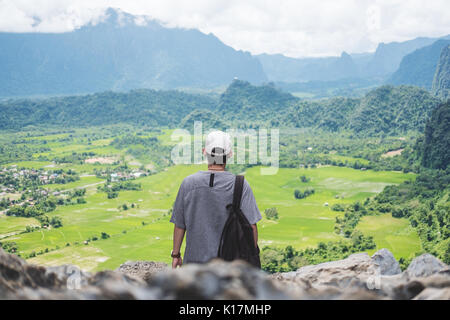 Giovane uomo con zaino godendo bellissimo natura vista sulla cima della montagna in Laos Foto Stock