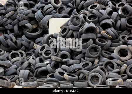 Vecchia auto pneumatici su una pila per il riciclaggio Foto Stock