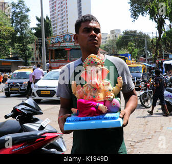 Mumbai, India. 24 Ago, 2017. Alla vigilia del Ganesh Chatuthi dieci giorni di festa per celebrare la nascita del Signore Ganesha che inizia il 25 agosto di quest'anno. Un devoto tenendo Signore Ganesha idoli di casa loro in occasione del Ganesha Chaturthi festival in Mumbai. Credito: Azhar Khan/Alamy Live News Foto Stock