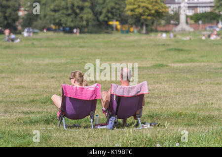 Londra, Regno Unito. 26 Ago, 2017. Un giovane seduto in sedie godendo il mite clima su Wimbledon Common come temperature più calde sono previsti durante il mese di agosto durante un weekend di ferie Credito: amer ghazzal/Alamy Live News Foto Stock