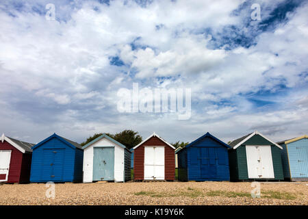 Una fila di pittoresca spiaggia di capanne a Mersea Island, Essex, Regno Unito Foto Stock