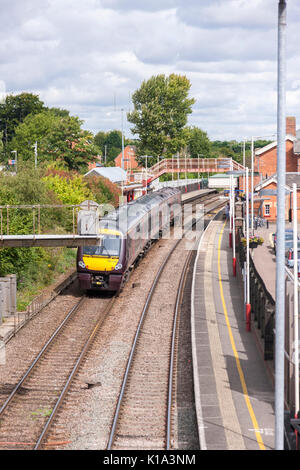 Treno diretto arcoss passaggio a livello in stazione a Oakham, Rutland.. U.K. Foto Stock