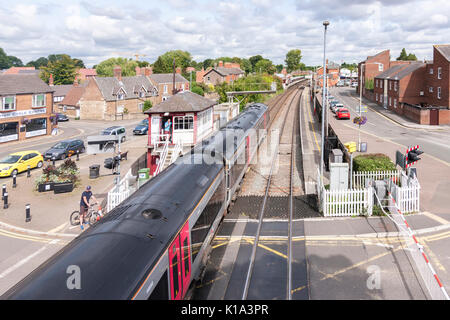 Treno diretto arcoss passaggio a livello in stazione a Oakham, Rutland.. U.K. Foto Stock