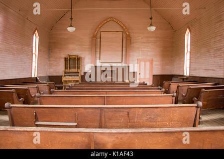 Banchi in legno rustico interno chiesa metodista di Bodie State Historic Park, Foto Stock