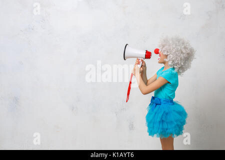 Bambino indossando costumi clown celebrazione di compleanno casse di contenimento Foto Stock