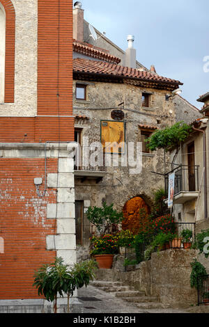 Suggestivi angoli del paese italiano. Vista di un antico edificio in muratura con passaggio illuminato e un'antica meridiana per la misurazione del tempo. M Foto Stock