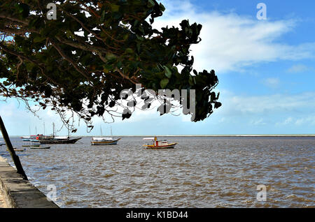 Piccole barche ancorate nel mare protetto da barriere coralline in Porto Seguro, Bahia, Brasile. Mandorla sul marciapiede dal mare. Foto Stock