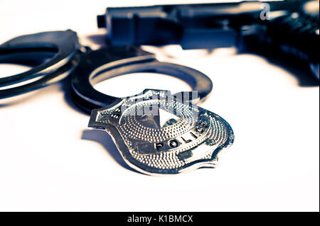 La pistola e manette badge di polizia Foto Stock