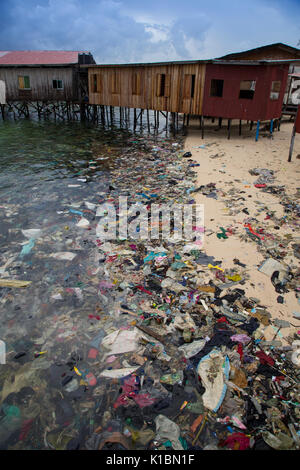 Immondizia di plastica e di altri rifiuti copre una spiaggia di fronte al bilancio dive resort sull'isola Mabul, Borneo Foto Stock
