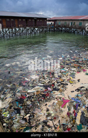 Immondizia di plastica e di altri rifiuti copre una spiaggia di fronte al bilancio dive resort sull'isola Mabul, Borneo Foto Stock