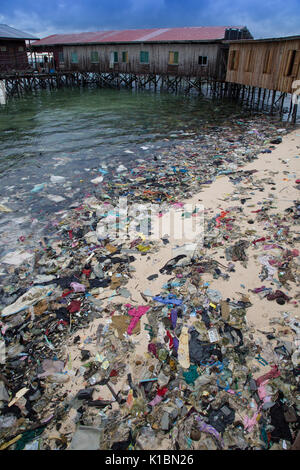 Immondizia di plastica e di altri rifiuti copre una spiaggia di fronte al bilancio dive resort sull'isola Mabul, Borneo Foto Stock