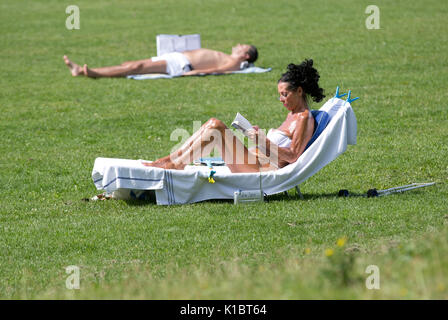 Persone sole in Hyde Park, London, come i britannici godono di alti di predizione di 27C (81F) dopo un umido e fresco Agosto. Foto Stock