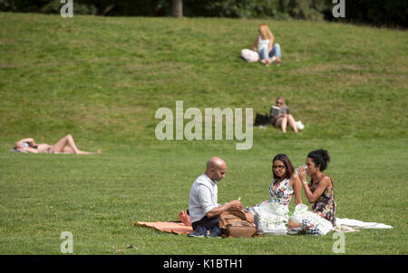 Persone sole in Hyde Park, London, come i britannici godono di alti di predizione di 27C (81F) dopo un umido e fresco Agosto. Foto Stock