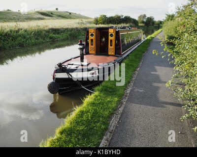 Tradizionale narrowboat dipinta in stile rimorchiatore ormeggiato in campagna Foto Stock