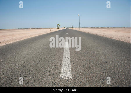 Lunghe e diritte strade del deserto in remote arido paesaggio andando a infinito punto di fuga Foto Stock