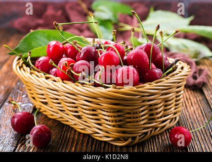 Fresh cherry nel cestello e su un tavolo Foto Stock