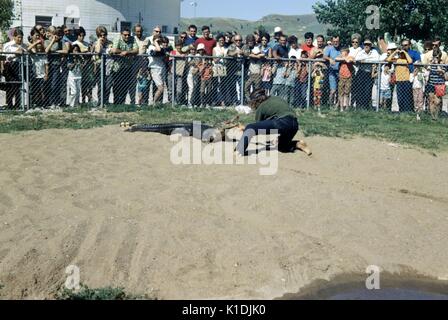 Attore preparando per combattere un alligatore, con una folla cercando, in corrispondenza dei giardini del rettile Wild Animal Park, South Dakota, 1975. Foto Stock