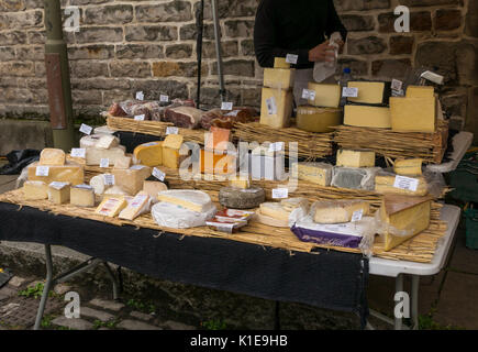 Dock Place, Leith, Edimburgo, Scozia, Regno Unito. Bancarella di cibo al mercato di Leith Sabato, con l'uomo dietro il chiosco del formaggio Foto Stock