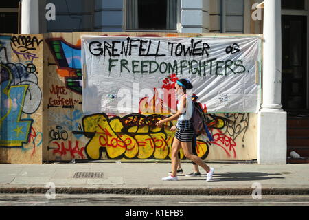 Londra, Regno Unito. Il 27 agosto 2017. Il primo giorno del carnevale di Notting Hill si svolge. Il recente incendio presso Grenfell Torre, vicino alla sfilata di route non è stato dimenticato, graffitti in diversi punti lungo la sfilata si riferisce al fuoco e un minuto di silenzio è stato trattenuto per ricordare coloro che sono morti o hanno sofferto a causa del fuoco . Roland Ravenhill/Alamy Live News. Foto Stock