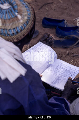 Niger, Doutouel Village, Africa occidentale. Notebook di uomo adulto frequentando corsi di alfabetizzazione. Foto Stock