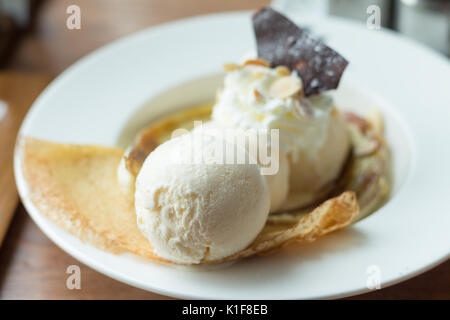 Crêpe con gelato e banana bruciato topping. Una crêpe è un tipo di molto sottile pancake (soft focus) Foto Stock