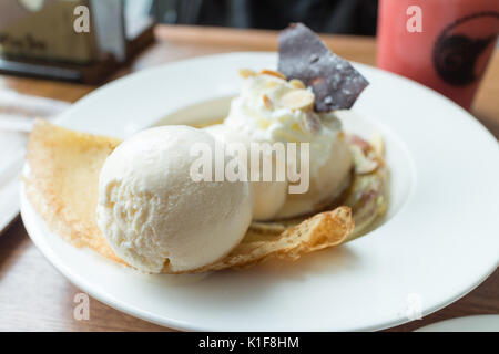 Crêpe con gelato e banana bruciato topping. Una crêpe è un tipo di molto sottile pancake (soft focus) Foto Stock