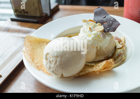 Crêpe con gelato e banana bruciato topping. Una crêpe è un tipo di molto sottile pancake (soft focus) Foto Stock