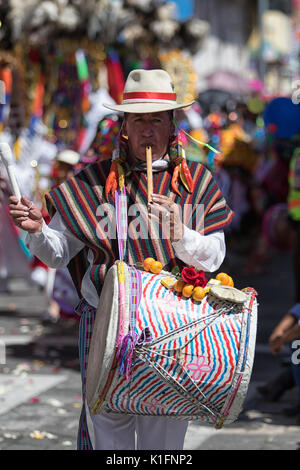 Giugno 17, 2017 Pujili, Ecuador: l'uomo gioca su flauto e tamburo simultaneamente a piedi il Corpus Christi parade Foto Stock