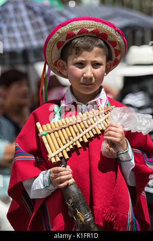 Giugno 17, 2017 Pujili, Ecuador: giovane ragazzo in abbigliamento tradizionale presso il Corpus Christi parade tenendo un flauto di pan Foto Stock