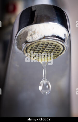 Il vecchio perde il rubinetto con pietra e sedimenti di calcio a causa di acqua dura. Foto Stock