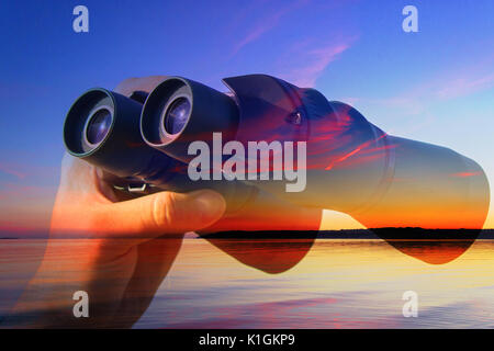 Binocolo in Le Mans le mani sullo sfondo del mare Foto Stock