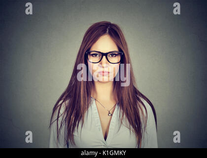 Ritratto di angry orinato donna che guarda la telecamera isolata sul muro grigio sfondo Foto Stock