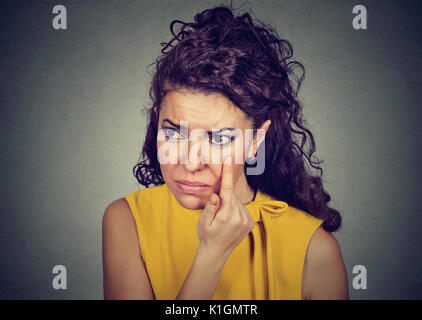 Donna tirando verso il basso la palpebra controllando il suo occhio cercando in morrow si sente male ha cerchi neri Foto Stock