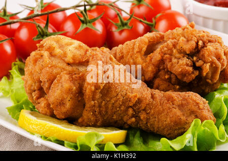 Cosce di pollo disossate di pollo nel pangrattato con pomodori e insalata di close-up Foto Stock