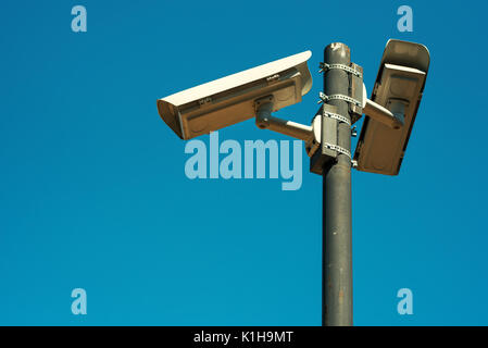 Due videocamere di sicurezza CCTV montato su alte post per la scuola cantiere la sorveglianza e il controllo Foto Stock