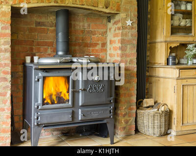 Una ghisa esse ironheart stufa a legna, acceso in un paese britannico cucina. Foto Stock