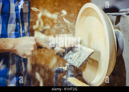 L'uomo girando un piatto di legno su un tornio Foto Stock