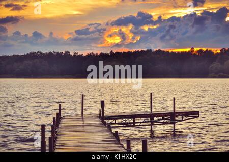 Il molo di legno sul lago. Paesaggio di sera sul lago. Foto Stock