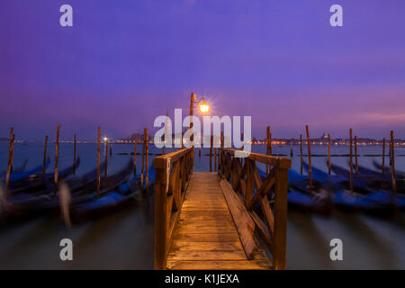 Gondole al crepuscolo con l'isola di San Giorgio Maggiore in background. Foto Stock