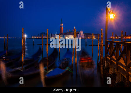 Gondole al crepuscolo con l'isola di San Giorgio Maggiore in background. Foto Stock