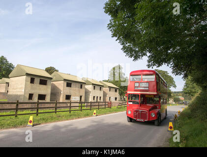 Un autobus Routemaster aziona attraverso il villaggio abbandonato di Imber sulla Piana di Salisbury, Wiltshire. Foto Stock